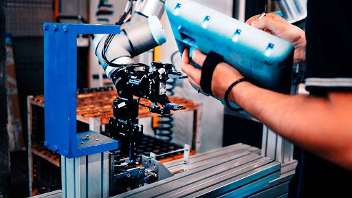 A cobot being trained through manual manipulation to assist workers